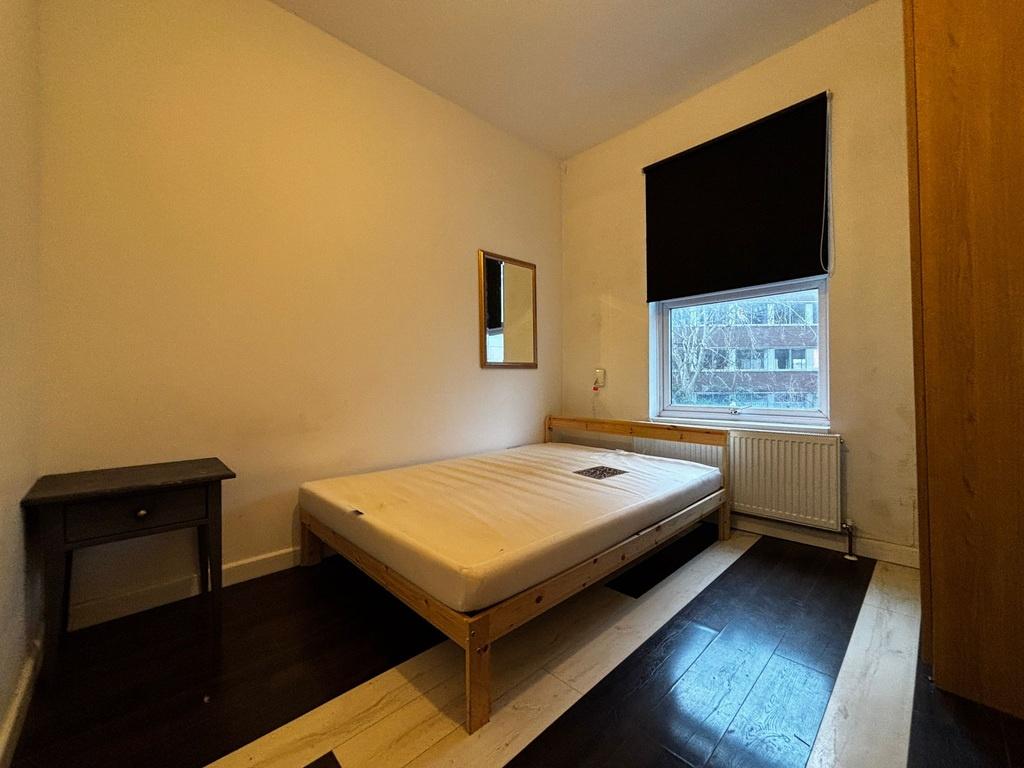 Bright, simply furnished bedroom with a double ...