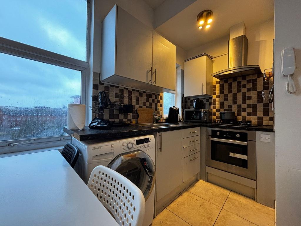 Modern compact kitchen with patterned tile spla...