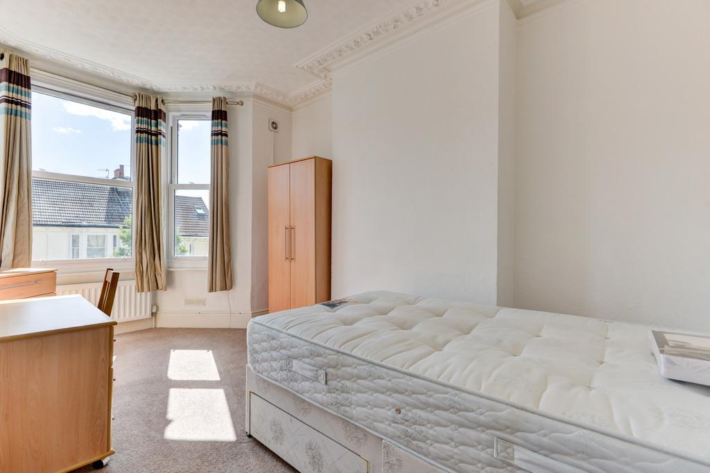 A bright single bedroom featuring a large windo...
