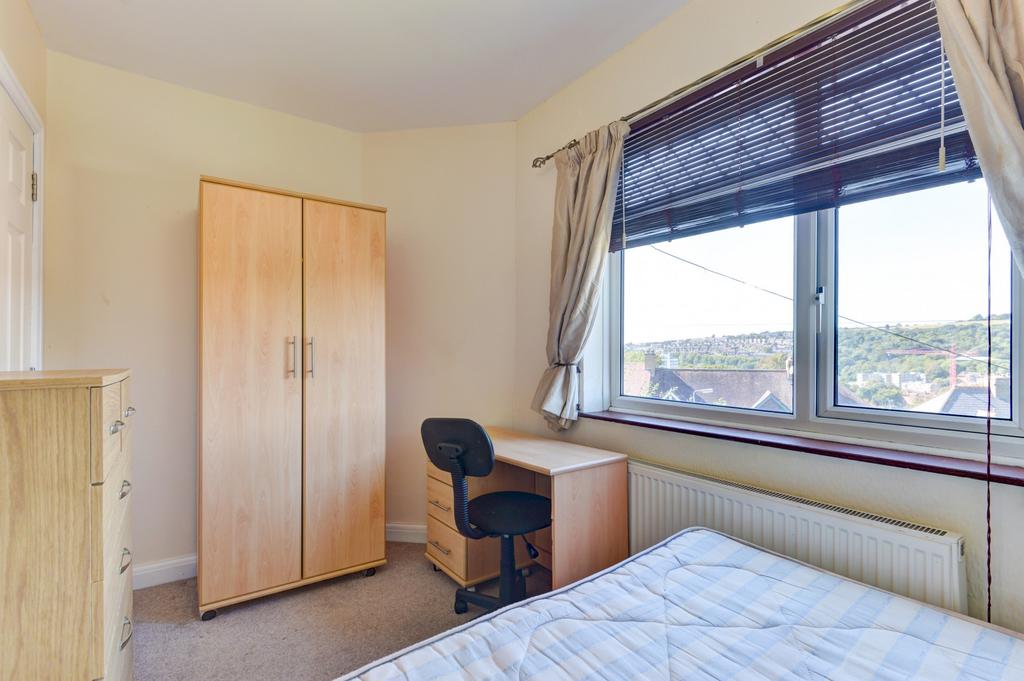 A bright and tidy bedroom featuring a large win...