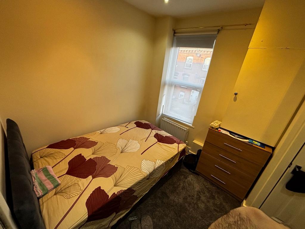 Cozy single bedroom with a neatly made bed, fit...