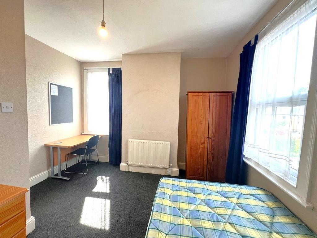 Bright, simply furnished bedroom with large win...