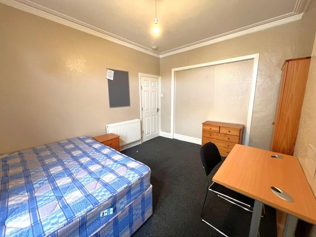 Bright furnished bedroom with a double bed, stu...