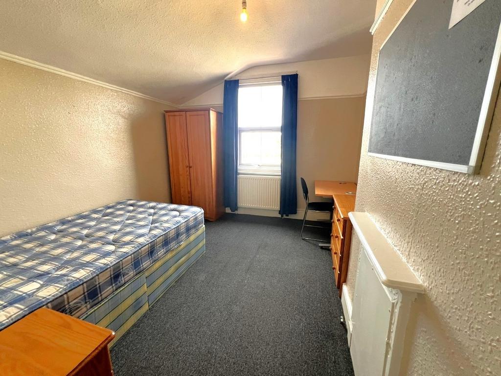 Bright, simply furnished single bedroom with a ...