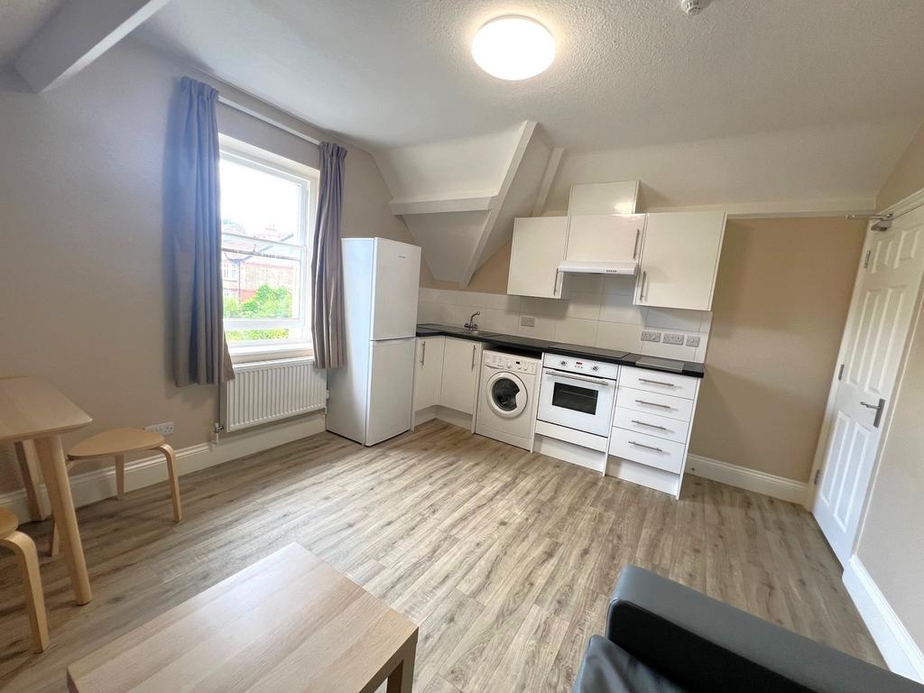 Bright open-plan kitchenette with modern white ...