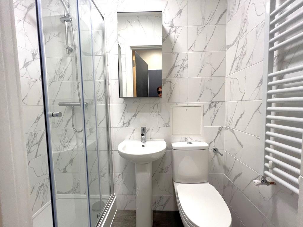 Bright modern bathroom with a glazed shower enc...