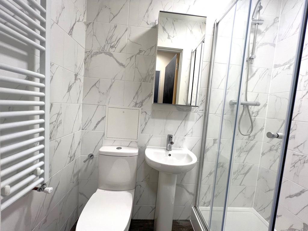 Modern bathroom featuring white marble-patterne...