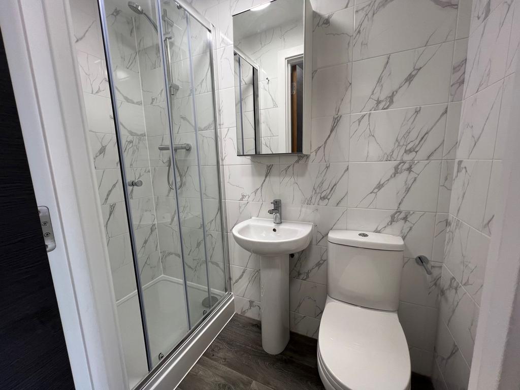 A modern bathroom featuring a spacious shower e...