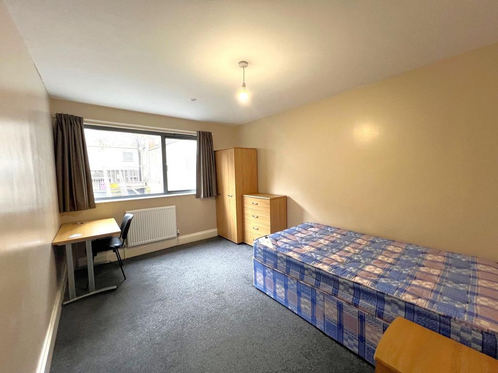 Bright, simply furnished single bedroom with a ...