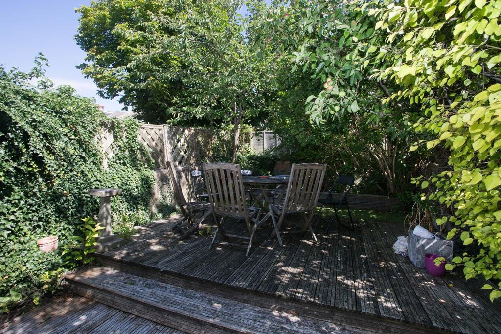 Private leafy garden with wooden decking, outdo...
