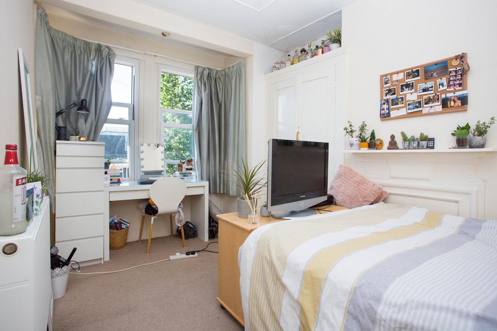 A bright and welcoming bedroom featuring a comf...