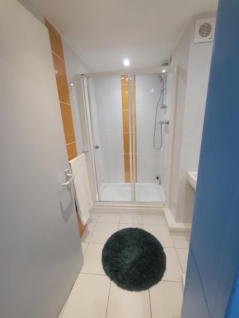 Bright, modern bathroom featuring a tiled walk-...