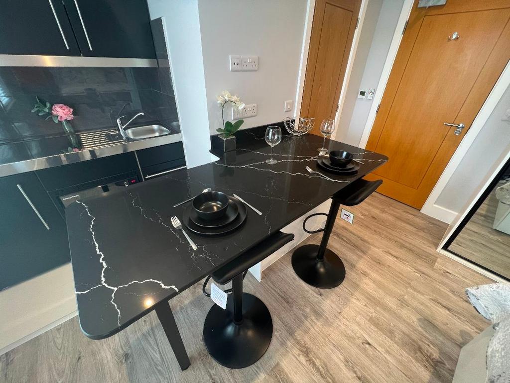 Modern kitchenette with a sleek black marble-ef...
