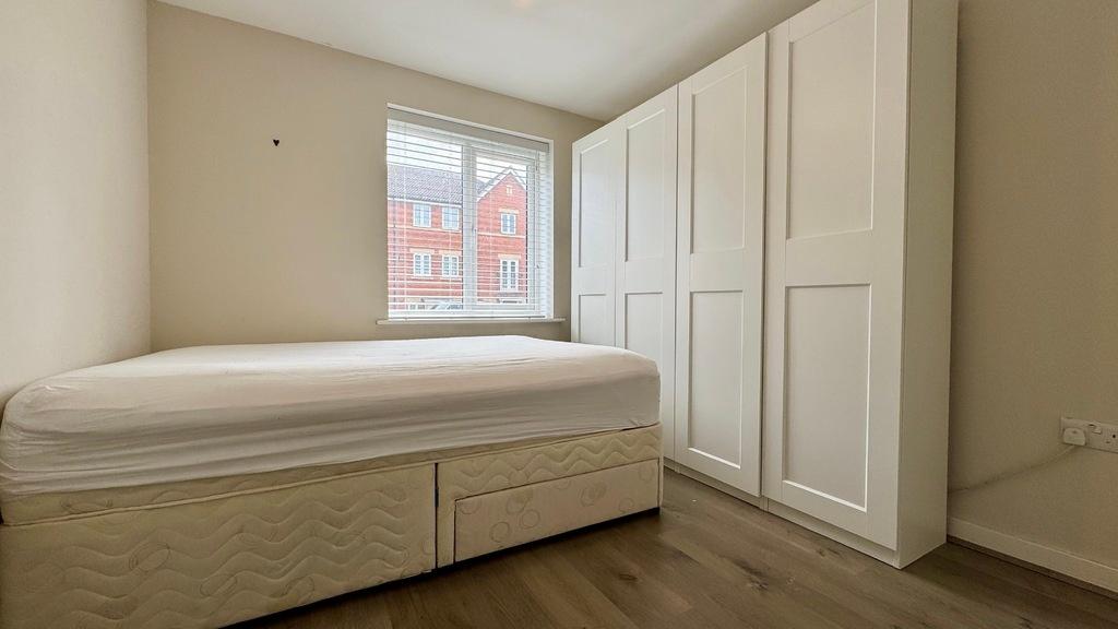 Neat, simply furnished bedroom with a comfortab...