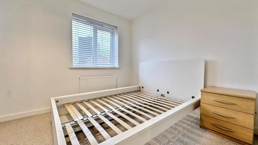 Bright, simply furnished bedroom with a large w...