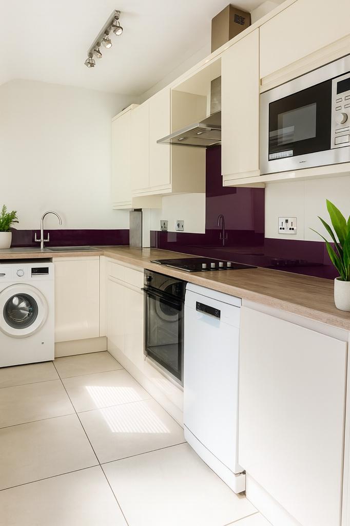Bright modern kitchen with sleek cream cabinetr...