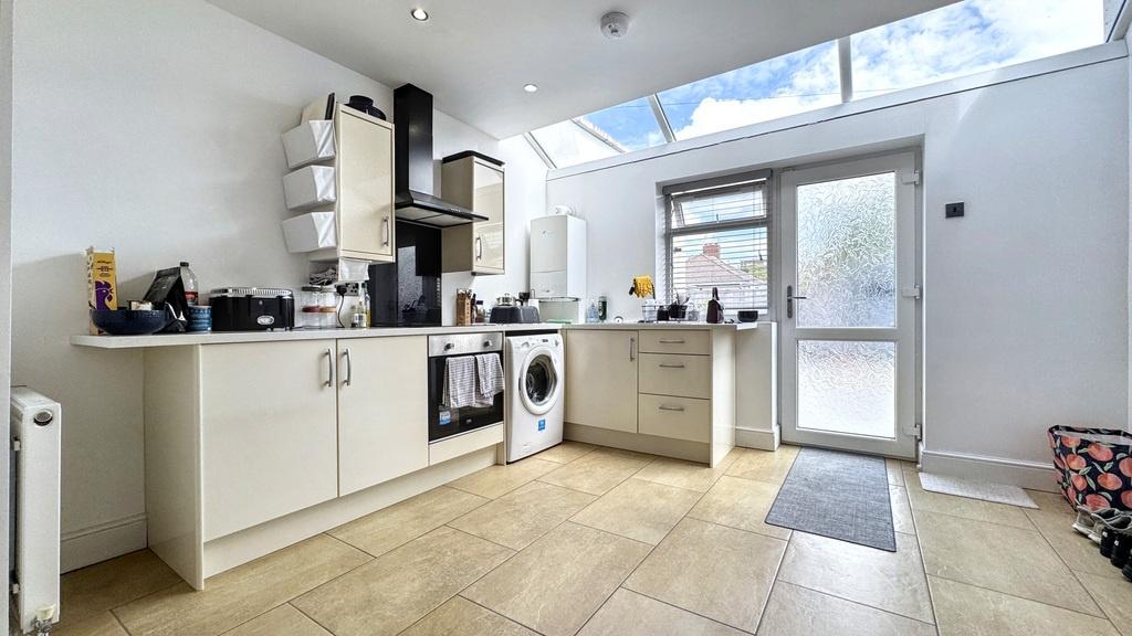 Bright modern kitchen with white cabinets, inte...