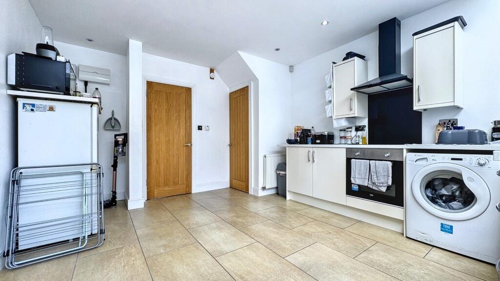 Bright modern kitchen with white cabinetry, int...