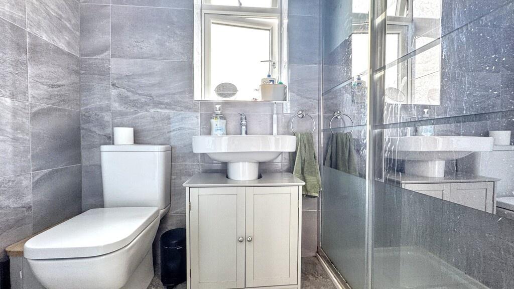Bright, modern bathroom with grey tiled walls, ...