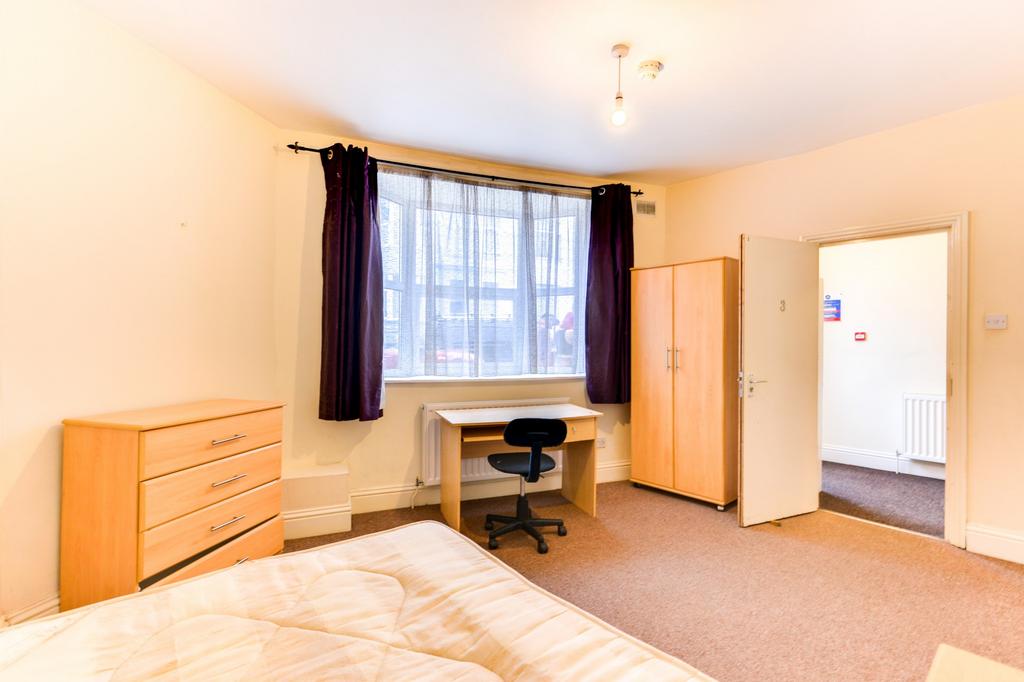 A bright and welcoming bedroom featuring a larg...