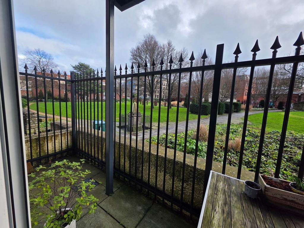 Ground-floor view across a gated courtyard and ...