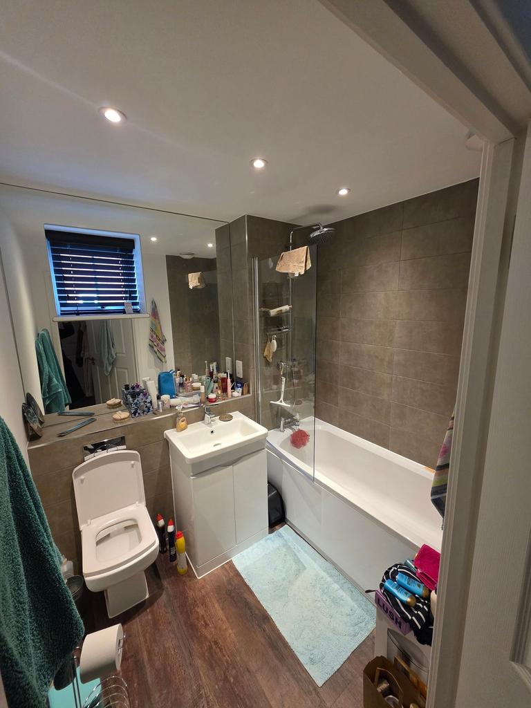 Modern tiled bathroom with a bath and overhead ...
