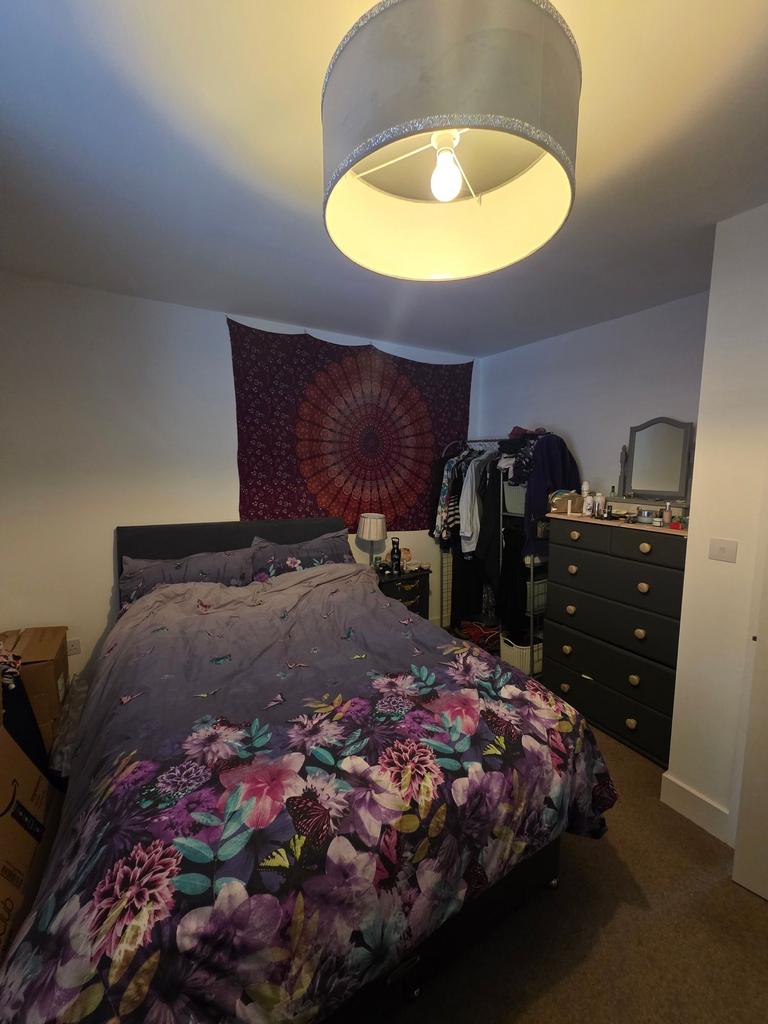 Cosy double bedroom with a patterned floral duv...