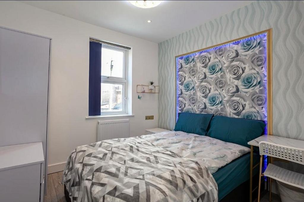 Bright, modern double bedroom with patterned fe...