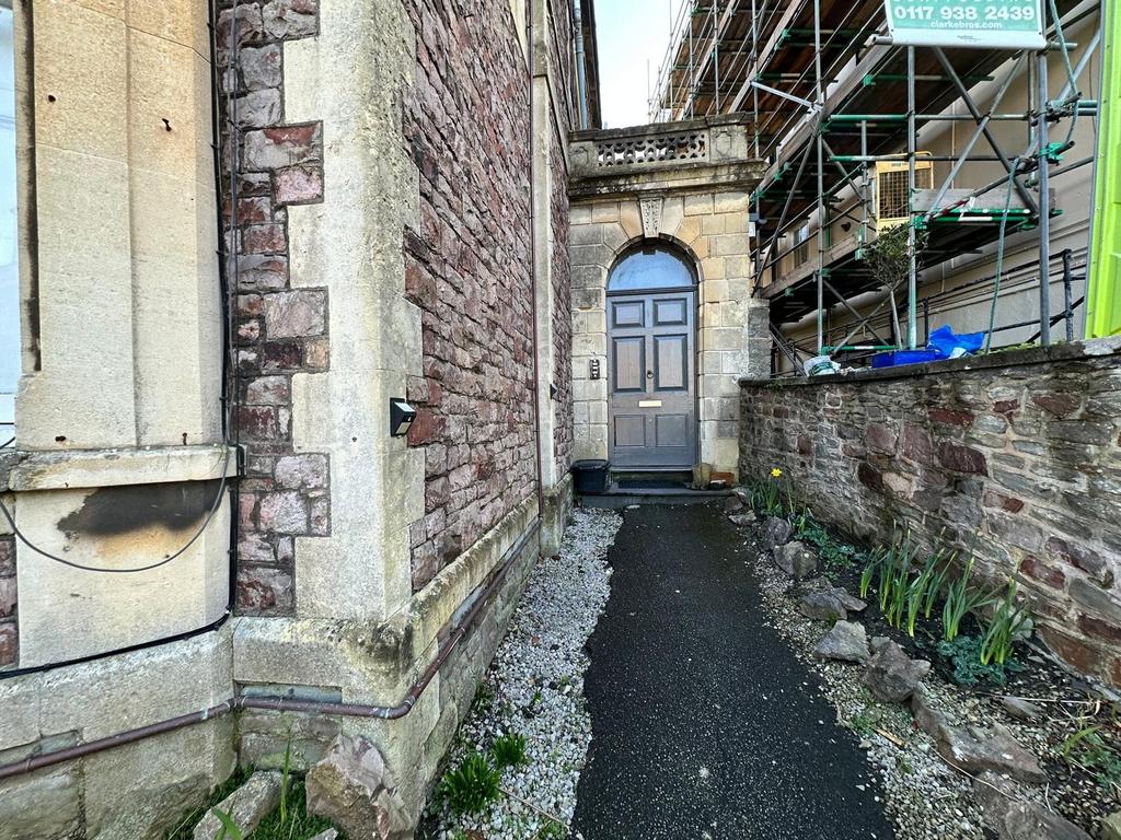 Stone-built property entrance with an arched do...