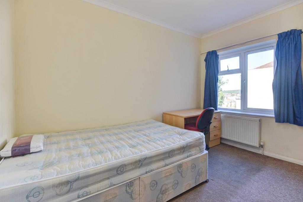 A tidy bedroom with a single bed placed against...