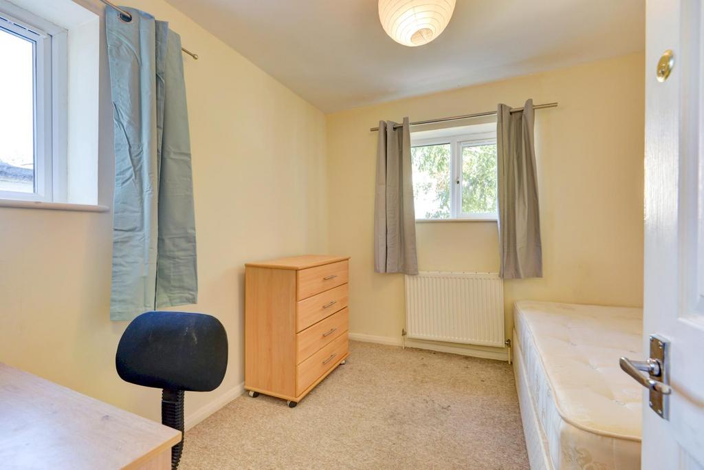 A cozy and well-lit single bedroom featuring a ...