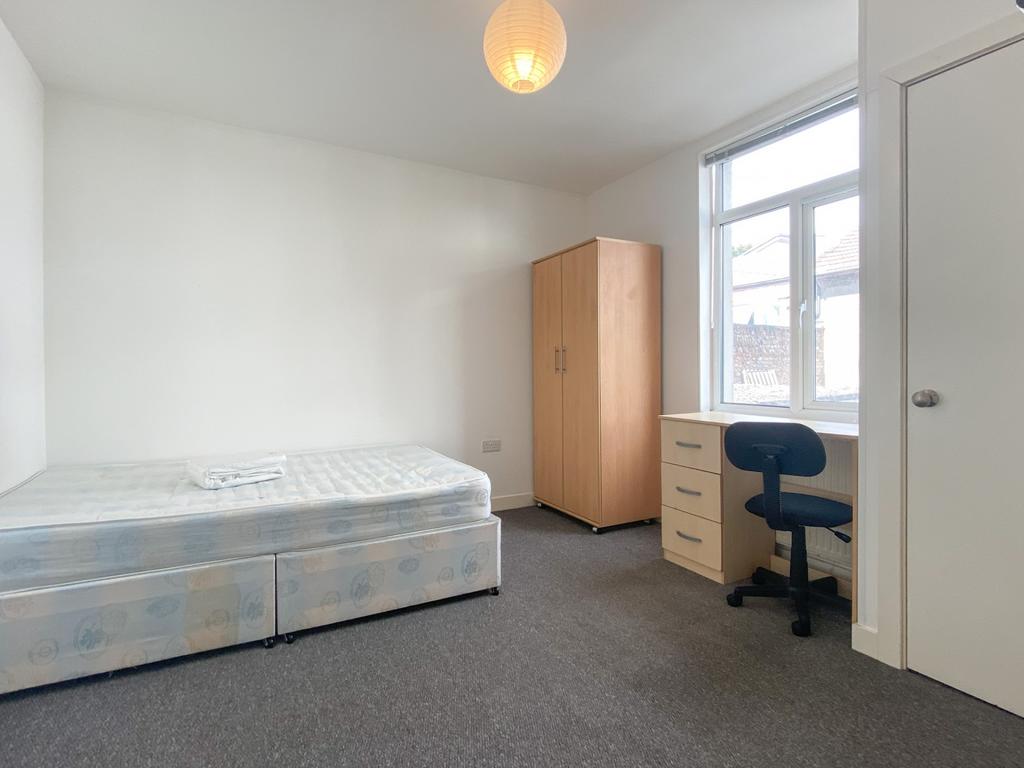 Bright, simply furnished bedroom with a double ...