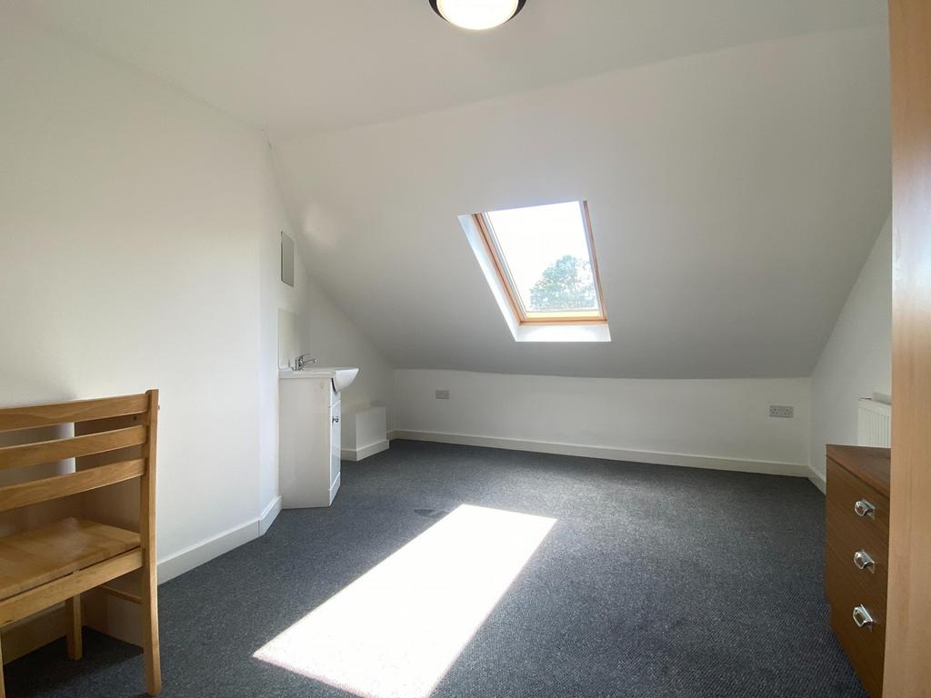 Bright attic bedroom with a large skylight, neu...