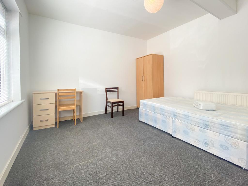 Bright, simply furnished bedroom with large win...