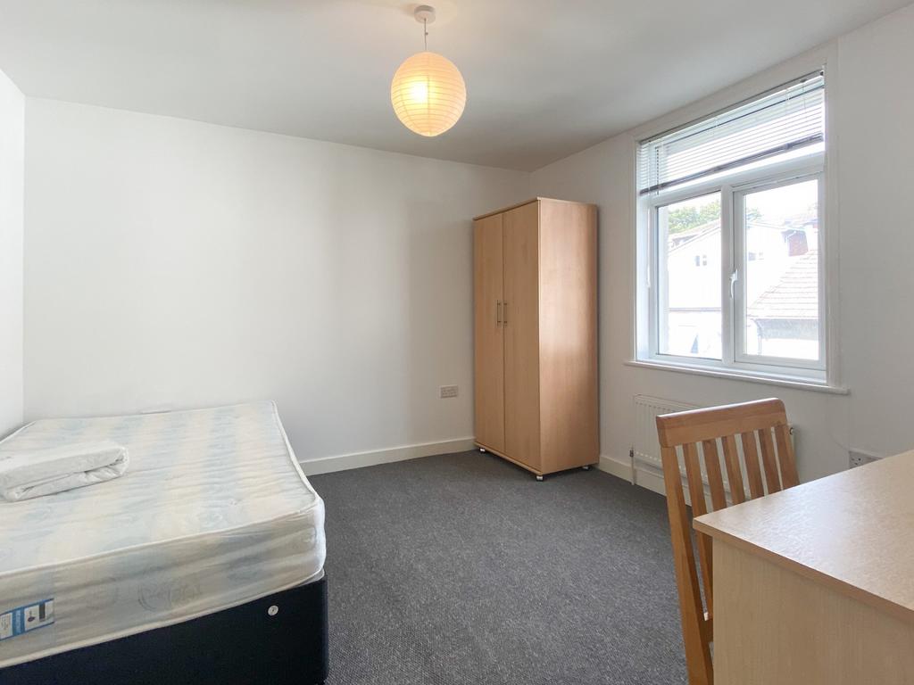 Bright, simply furnished bedroom with a large w...
