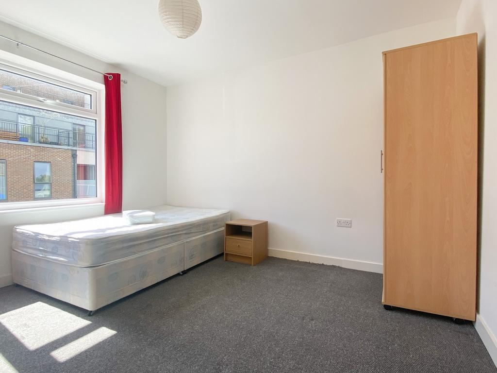 Bright, simply furnished bedroom with a large w...