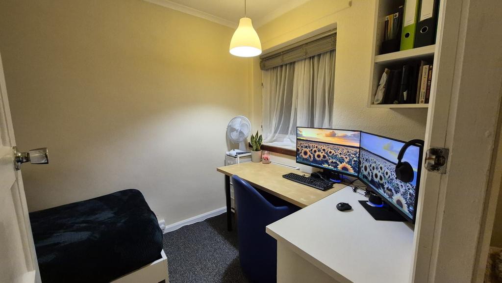 Cozy single bedroom with a tidy study setup fea...