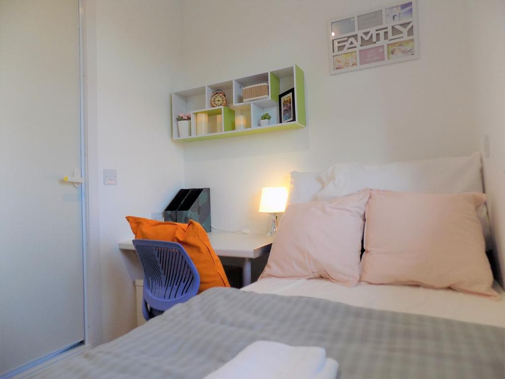 Bright, neatly styled bedroom with a compact st...