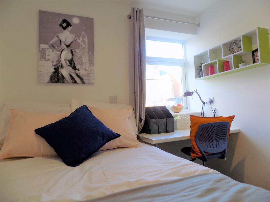 Bright, neatly arranged bedroom with a comforta...