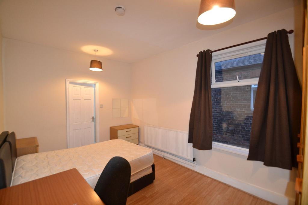 A cozy bedroom featuring a single bed and a sma...