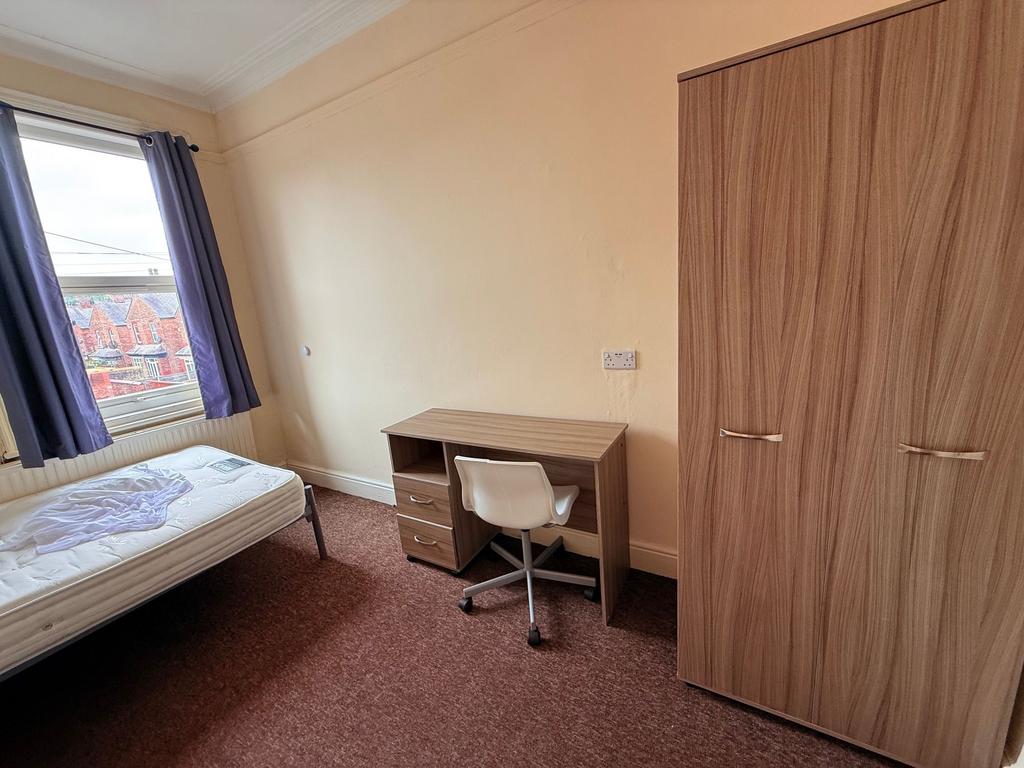 Bright single bedroom with a large window, fitt...