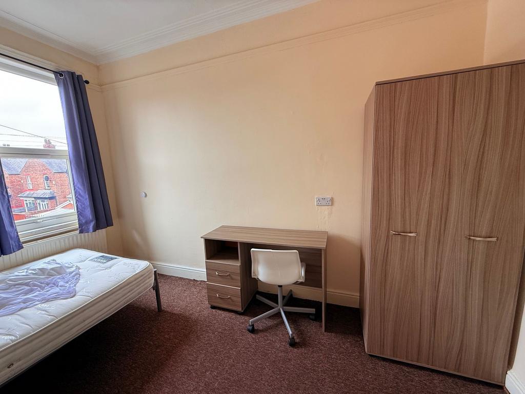 Bright bedroom with a large window, fitted ward...