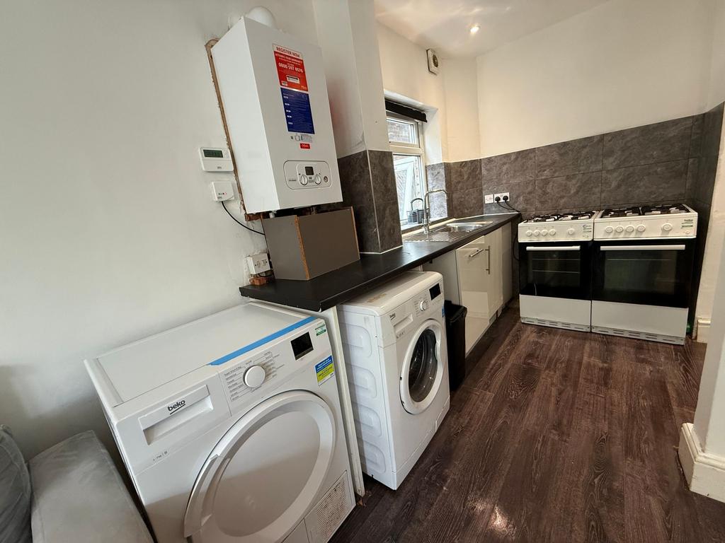 Well-equipped galley kitchen with dark countert...