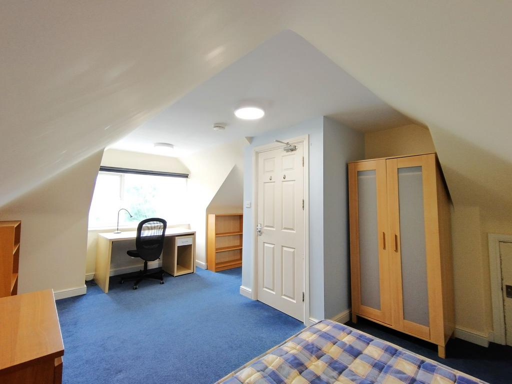 Bright, well-appointed attic bedroom with a stu...