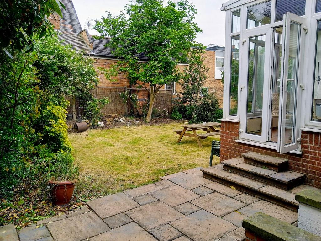 Private rear garden with paved patio leading to...