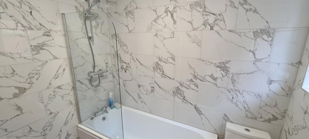 Modern bathroom with elegant marble-look wall t...