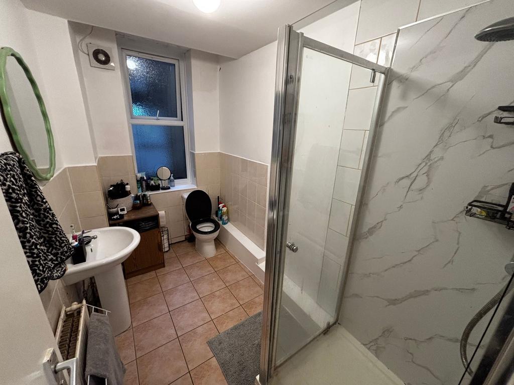 Bright bathroom with a walk-in shower featuring...