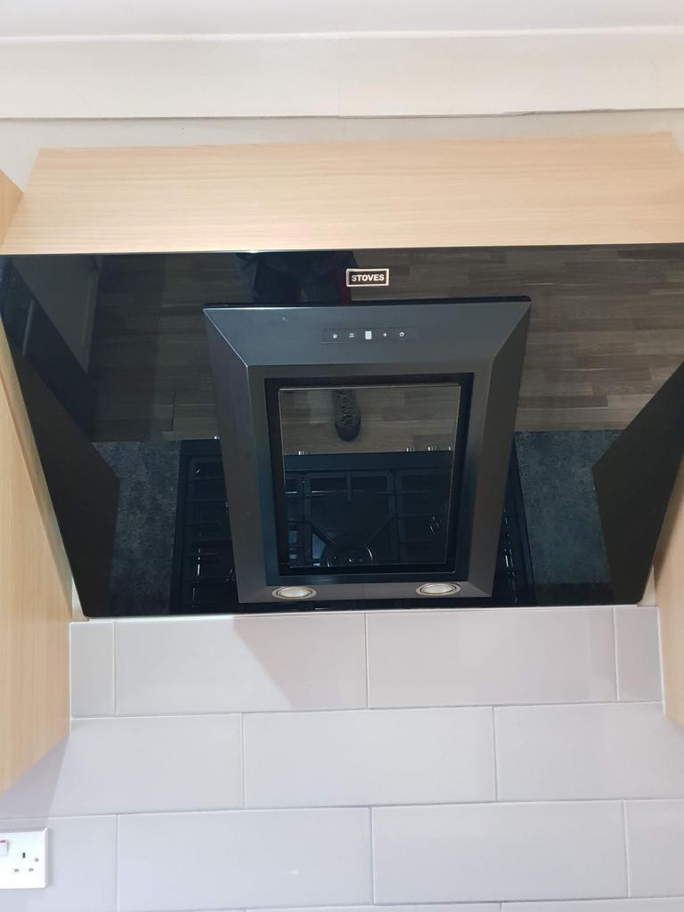 Contemporary kitchen hood and gas hob set into ...
