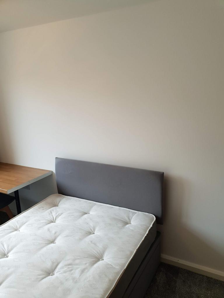 Bright, simple bedroom with a comfortable doubl...