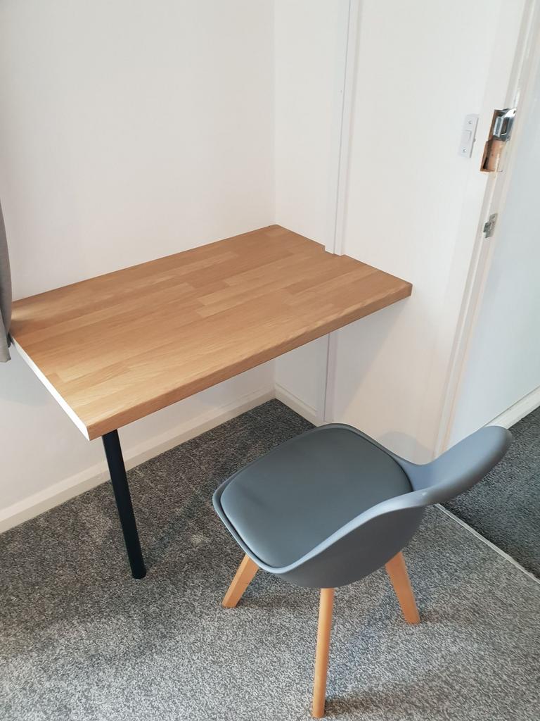 Compact built-in wooden desk with a modern grey...